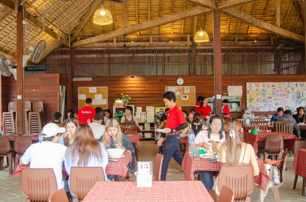 Busy thatched-roof dining hall at Branch 1